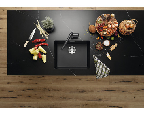 Küchenspüle mit Armatur auf einer Küchentheke mit Lebensmitteln.