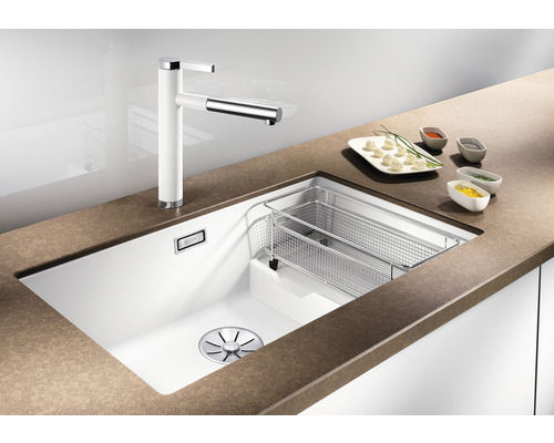 Spüle mit Armatur und Abtropfkorb in einer Küchenumgebung.