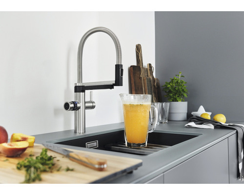 Küchenszene mit Spültischarmatur, Spüle und Küchenutensilien.