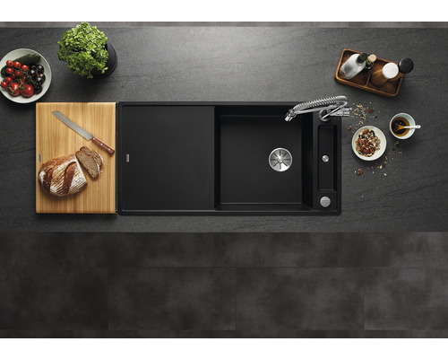 Küchenspüle aus Granit mit Spültischarmatur, Schneidebrett und Lebensmitteln auf einer Küchentheke
