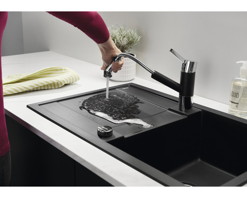Schwarze Küchenspüle mit Wasserhahn und Handbrause.