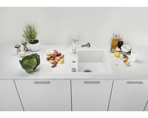 Küchenszene mit Spüle, Armatur und Gemüse auf einer Arbeitsplatte