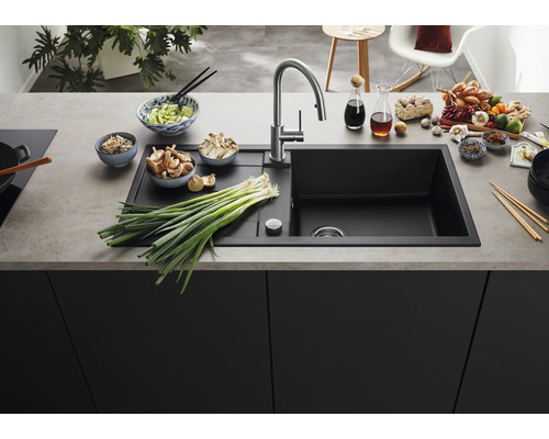 Küchenspüle aus Verbundmaterial mit Abtropffläche und verschiedenen Lebensmitteln