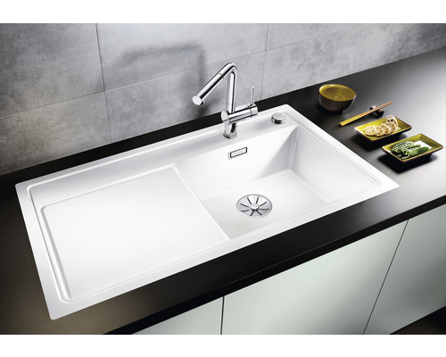 Weiße Küchenspüle mit Abtropffläche und Chromarmatur auf einer Küchentheke