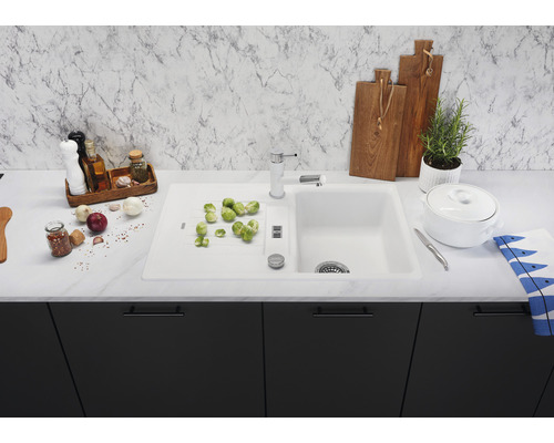 Küchenspüle mit Abtropffläche, Armatur und diversem Küchenzubehör auf einer Küchentheke