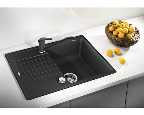 Spüle aus Granit mit Abtropffläche und Armatur auf einer Küchentheke mit Zitronenkorb