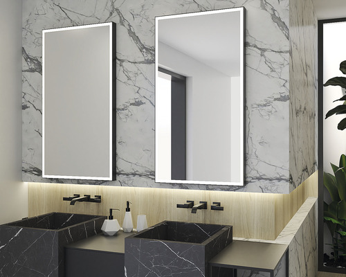 Badezimmer mit zwei beleuchteten Spiegeln, zwei Waschbecken aus Marmor und Armaturen