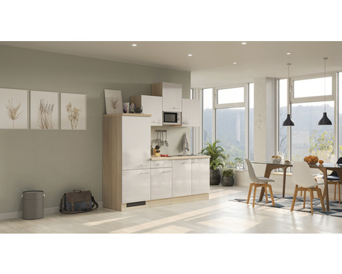 Kompakte Küchenzeile in einem hellen und modernen Raum mit Essbereich und großen Fenstern.