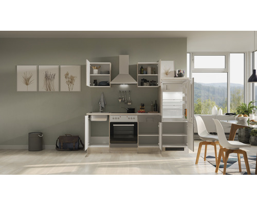 Komplette Küchenzeile mit Spüle, Herd, Backofen, Dunstabzugshaube, Hängeschränken und Kühl-Gefrierkombination in einer hellen, modern eingerichteten Küche.