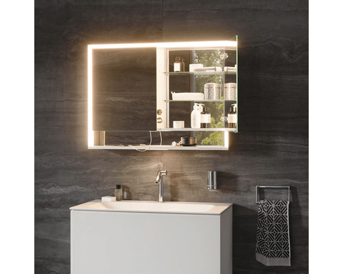 Badezimmer mit beleuchtetem Spiegelschrank, Waschbecken und Armatur