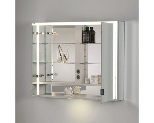 Geöffneter Spiegelschrank mit Glasböden, Beleuchtung und Badutensilien