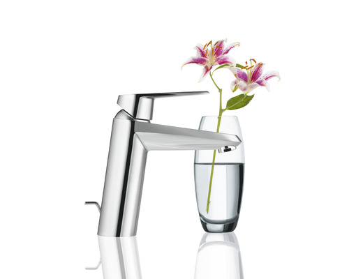 Moderner Wasserhahn aus Metall neben Blumenvase