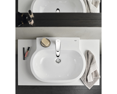 Aufnahme von oben eines Badezimmers mit Waschbecken, Armatur und Badaccessoires.