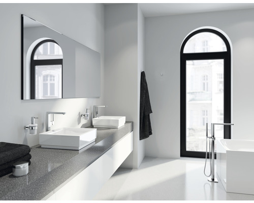 Helles Badezimmer mit Doppelwaschbecken, Spiegel und Badewanne vor einem Fenster