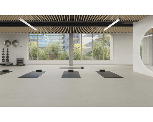 Heller Fitnessraum mit Yogamatten, Hanteln und großem Fenster