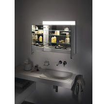 Badezimmer mit Waschbecken, Armatur und beleuchtetem Spiegelschrank mit Glasregalen