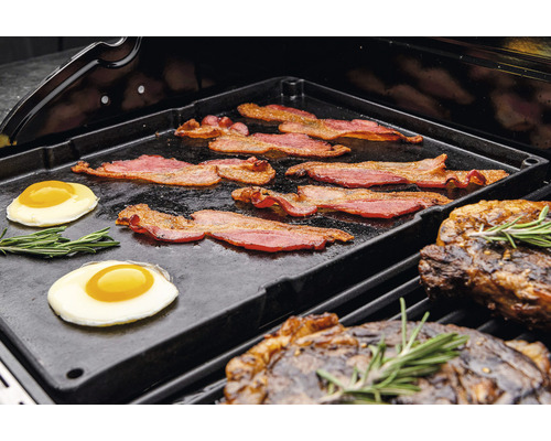 Speck, Spiegeleier und Steaks auf einer Grillplatte