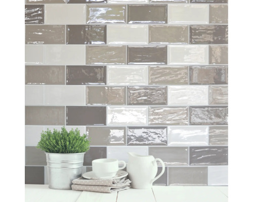 Wandgestaltung mit rechteckigen Fliesen in verschiedenen Grautönen