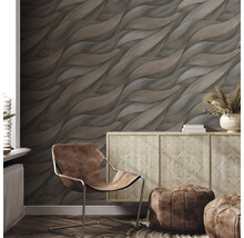 Wohnraum mit brauner Design-Tapete, Kommode und Ledersessel