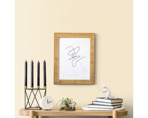 Dekorative Szene mit Kerzen, Uhr, Pflanze, Rahmen und Dekofigur auf einem Tisch