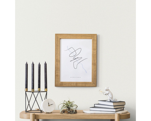 Dekorative Szene mit Kerzen, Bilderrahmen und Accessoires auf einem Tisch.