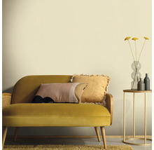 Wohnzimmer mit gelbem Sofa, Kissen, Beistelltisch und Vase