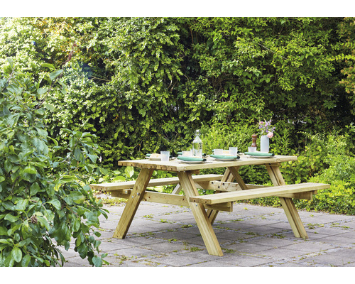 Gartenszene mit einem Holztisch mit Bänken im Freien