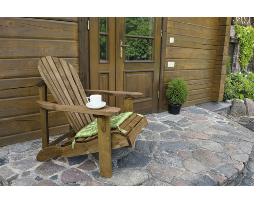 Holzstuhl mit Getränk vor einem Holzhaus