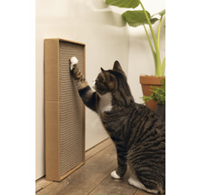 Katze kratzt an einem Kratzbrett aus Pappe an der Wand