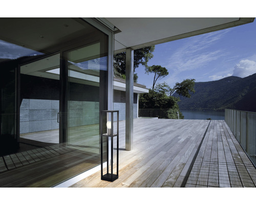 Szene mit einer modernen Stehleuchte auf einer Terrasse mit Seeblick.