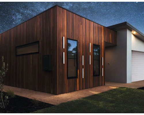 Modernes Haus mit Holzverkleidung, Aussenbeleuchtung und Sternenhimmel.