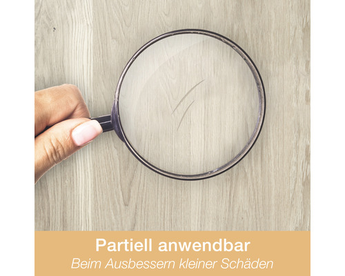 Lupe vergrößert kleine Kratzer auf einer Holzoberfläche