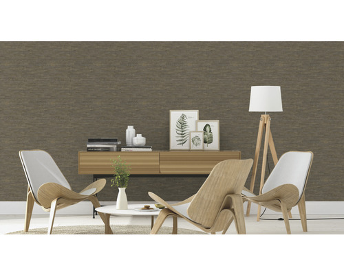 Wohnzimmer mit brauner Tapete, zwei Sesseln und einer Kommode mit Dekoration