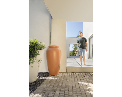 Regentonne in Amphorenform mit Wasserhahn im Außenbereich vor Haus