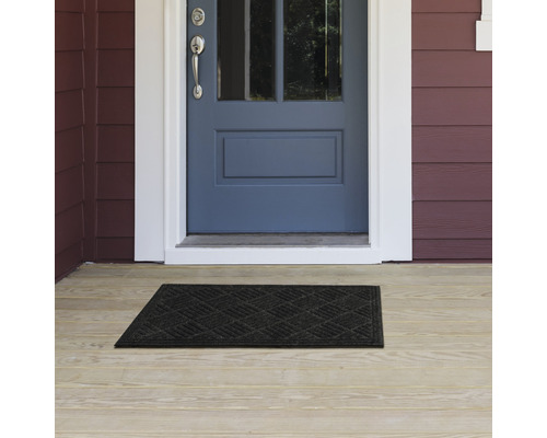 Fußmatte vor einer Haustür auf einer Veranda