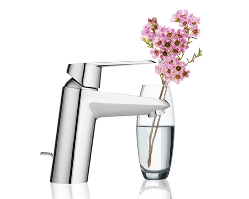 Glänzende Armatur neben einer Blumenvase.