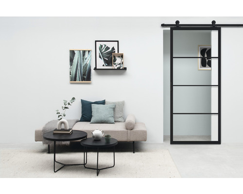 Wohnzimmer mit Tagesbett, Couchtischen, Wanddekoration und Glasschiebetür