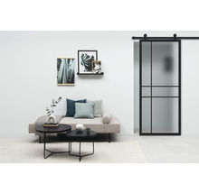 Wohnzimmer mit Sofa, Couchtischen, Wanddekoration und Schiebetür