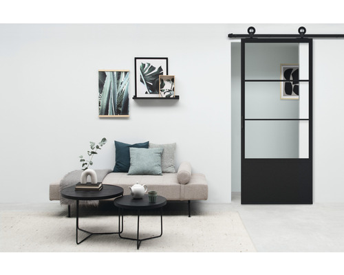 Wohnzimmer mit Sofa, Couchtischen, Wanddekorationen und Schiebetür im Industriedesign