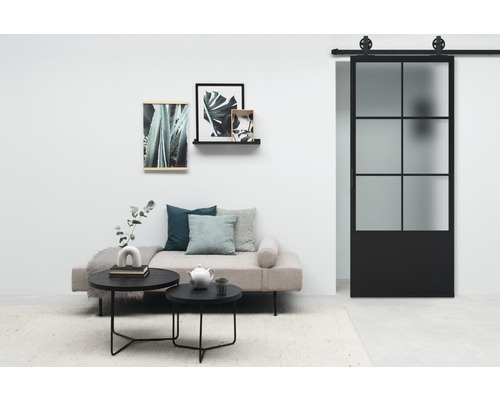 Wohnzimmer mit Sofa, Tisch, Wanddekoration und Schiebetür