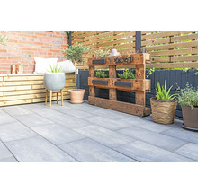 Terrasse mit Betonplatten, Holzbänken, Pflanzen und Dekorationen