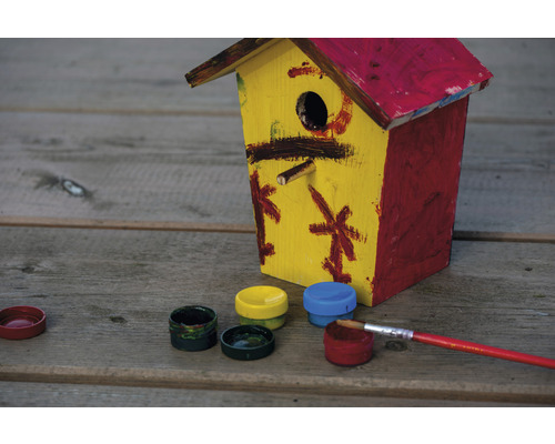 Bemaltes Vogelhaus aus Holz mit Farbtöpfen und Pinsel