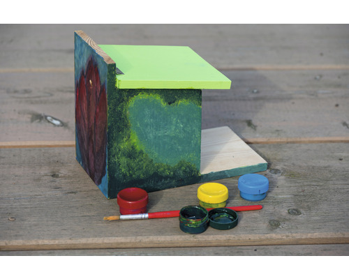 Bemaltes Vogelhaus mit Farben und Pinsel