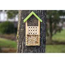 Insektenhotel aus Holz mit verschiedenen Nistmaterialien an einem Baum