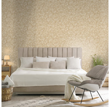 Schlafzimmer mit Bett, Kissen, Decke, Sessel und dekorativer Wandgestaltung
