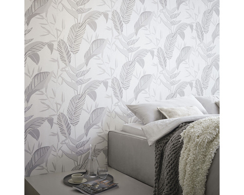 Wandgestaltung mit tropischem Blätter Tapetenmuster in einem Schlafzimmer.