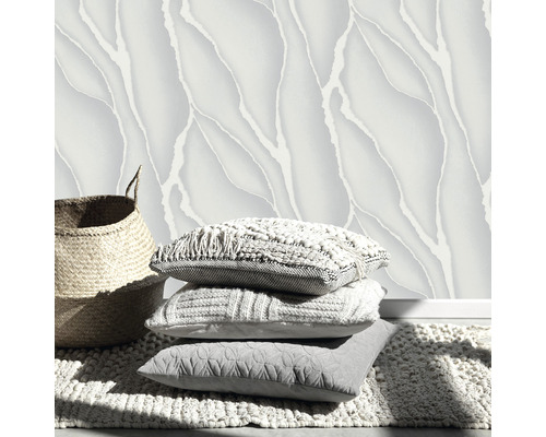 Dekorative Wandgestaltung mit gemusterten Tapeten, Kissenstapel und einem Korb auf einem Teppich