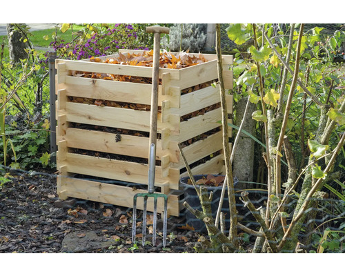 Komposter aus Holz mit Laub und einer Mistgabel