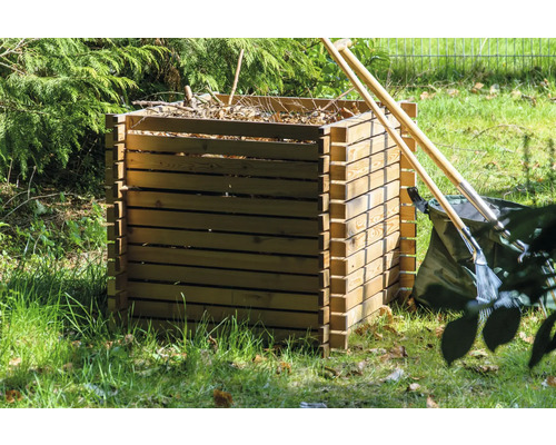 Holzkomposter im Garten mit Gartengeräten