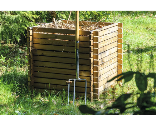 Holzkomposter im Garten mit einer Mistgabel